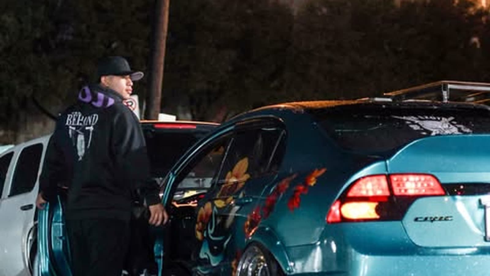 Cars lined up under the lights outside 7Fades Barbershop on Bissonnet